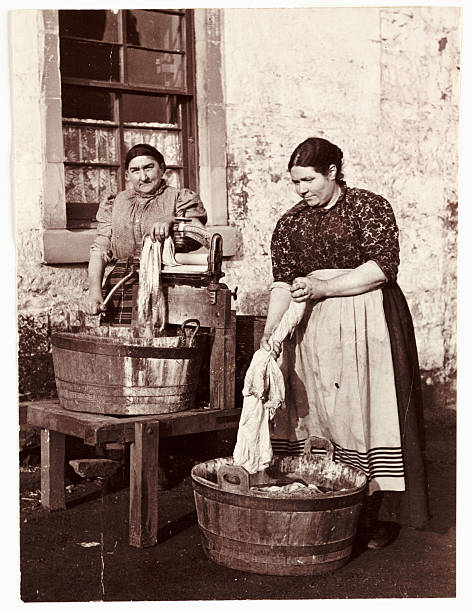 Image of women using old wringer washing machine